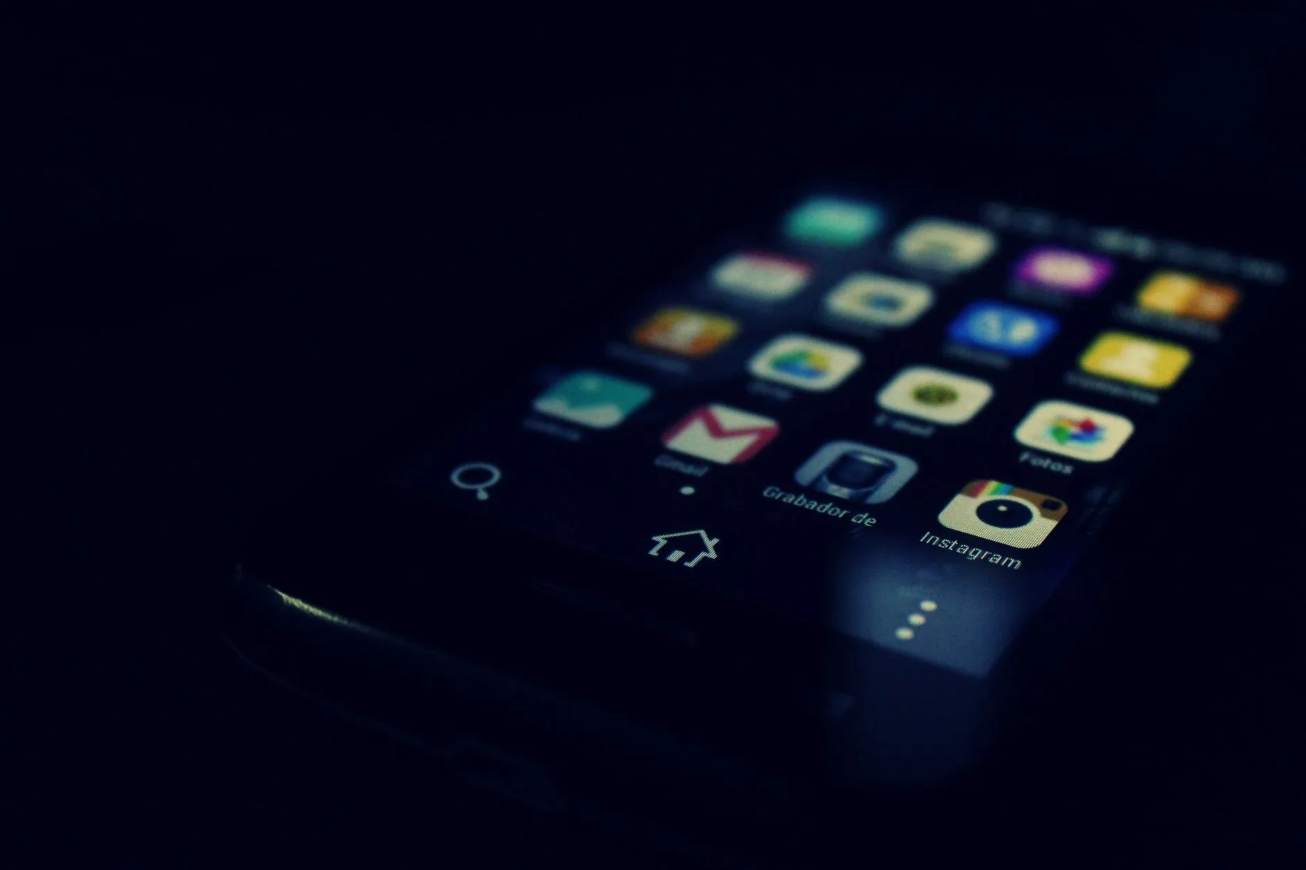 Écran de smartphone affichant plusieurs icônes d'applications mobiles en mode sombre