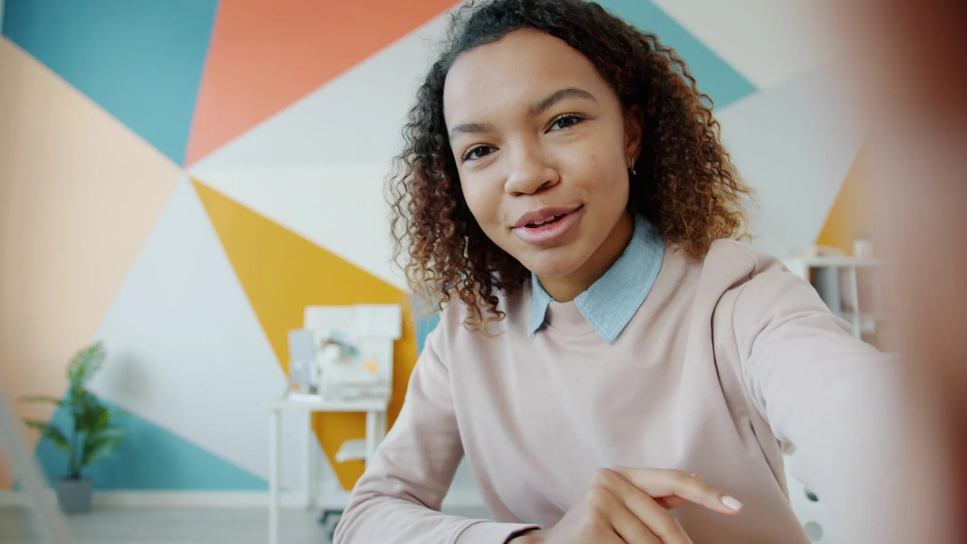 Personne souriante à son bureau pratiquant la conversation en anglais lors d'un appel vidéo