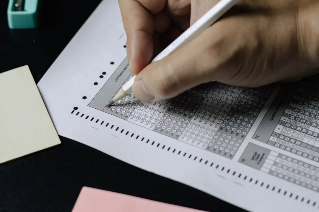 Personne complétant un formulaire à bulles avec un stylo sur une surface de travail