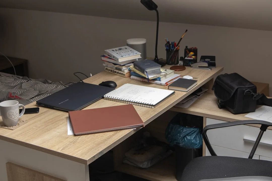 Bureau de travail avec pile de livres, ordinateur portable, cahier et fournitures pour étudier