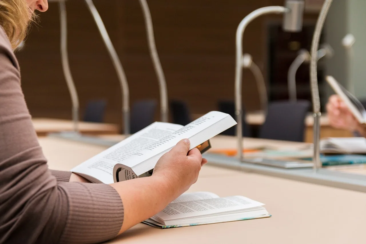 Personne lisant un document à une table de réunion ou de travail